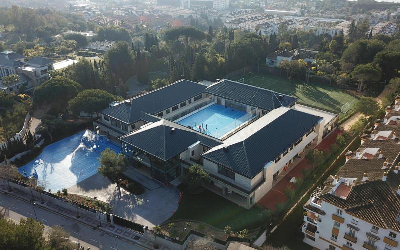 Aerial view of the British International School in Marbella with students in the courtyard and sports fields.