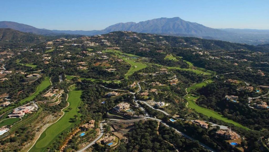 Aerial view of Marbella’s Golf Valley, showcasing lush green fairways, luxury estates, and the surrounding rolling hills
