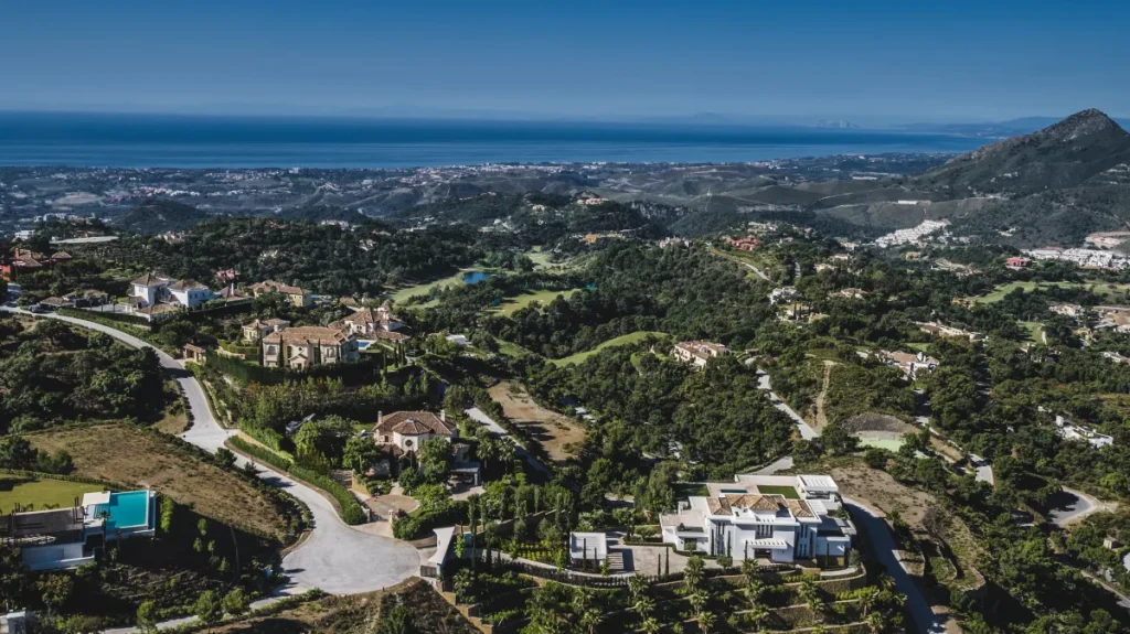 Aerial perspective of sprawling luxury estates in La Zagaleta, nestled in lush greenery with panoramic views stretching to the Mediterranean Sea.