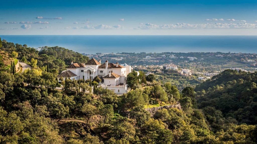 Luxury white villa perched on the lush hillside of La Zagaleta, offering expansive views of the Mediterranean Sea and Marbella's landscape.